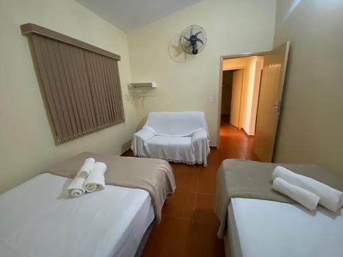 a room with two beds and a room with a fan at Hospedaria Spring in Alfenas