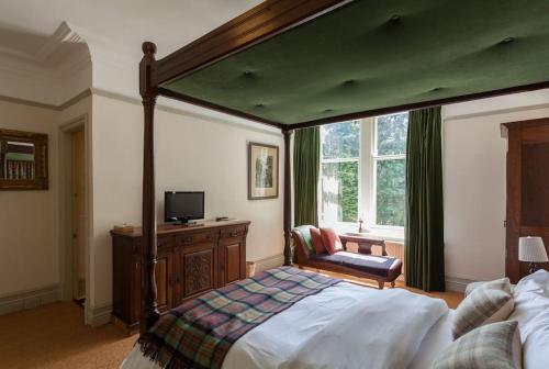 a bedroom with a large canopy bed and a chair at Woodlands House in Giggleswick