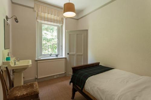 a bedroom with a bed and a sink and a window at Woodlands House in Giggleswick
