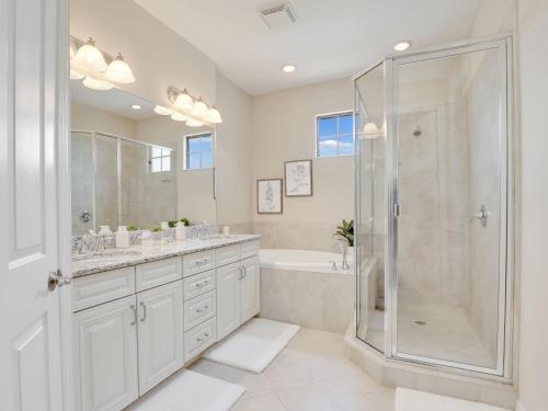 フォートマイヤーズにあるLuxury Paseo Townhome Pool Bars and Beachesのシャワーと洗面台を備えた白いバスルーム