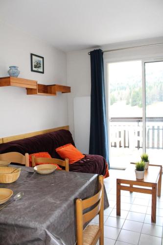 un salon avec un canapé et une table dans l'établissement Résidence Les Issarts - Appartement 4 couchages au pied des pistes MAE-8114, à Saint-Étienne-en-Dévoluy