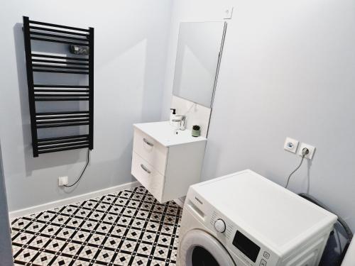 a washer and dryer in a bathroom with a black and white floor at AU BON PLAN in Maubeuge