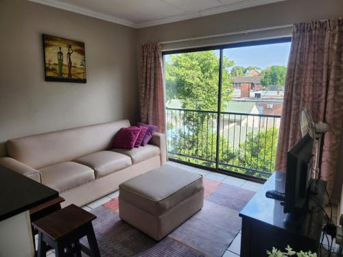 a living room with a couch and a large window at Three Flags in Pietermaritzburg