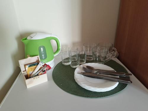 スバジェボにあるKaszub Swarzewo - Bed & Breakfastの緑のピッチャー付きテーブル、皿、グラス