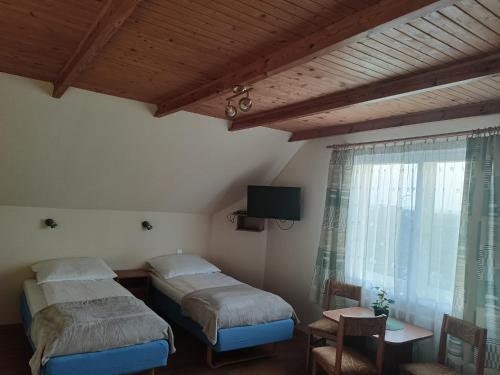 スバジェボにあるKaszub Swarzewo - Bed & Breakfastのベッドルーム1室(ベッド2台、テーブル、窓付)