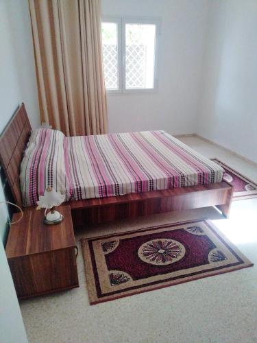a bedroom with a bed and a rug and a window at Dar Zohra in Tabarka