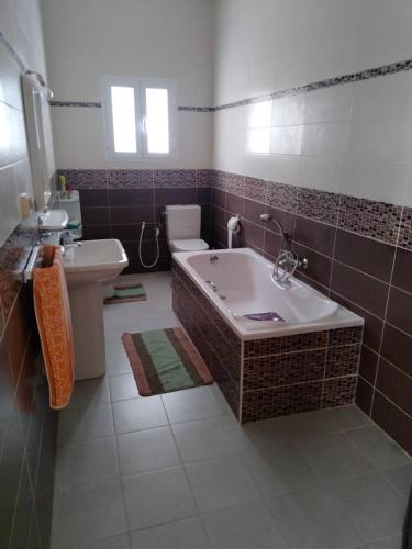 a bathroom with a tub and a toilet and a sink at Dar Zohra in Tabarka