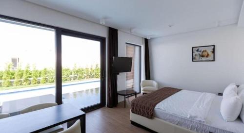 a hotel room with a bed and a large window at Sea Breeze White Villa in Baku