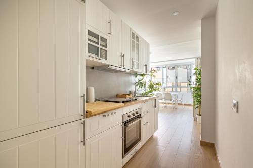 una cucina con mobili bianchi e pavimento in legno di Pursuit of Ocean a Las Palmas de Gran Canaria