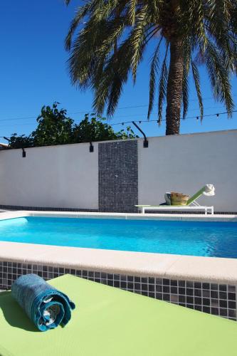 una piscina con una toalla junto a una palmera en Casa Iantmar 2 en El Altet