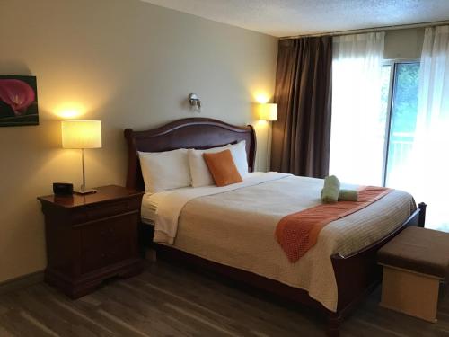 a hotel room with a bed and a window at Excelsior Hôtel Spa Sainte-Adèle in Sainte-Adèle