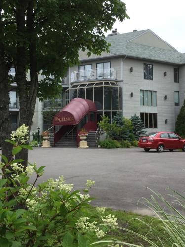 a red car parked in front of a building at Excelsior Hôtel Spa Sainte-Adèle in Sainte-Adèle