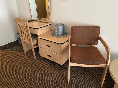 a chair sitting next to a desk with a mirror at Excelsior Hôtel Spa Sainte-Adèle in Sainte-Adèle