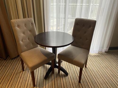 two chairs and a table in a hotel room at Excelsior Hôtel Spa Sainte-Adèle in Sainte-Adèle