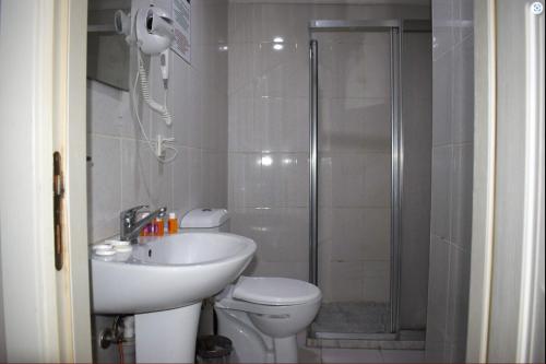 y baño con aseo, lavabo y ducha. en Kümbet Hotel, en Estambul