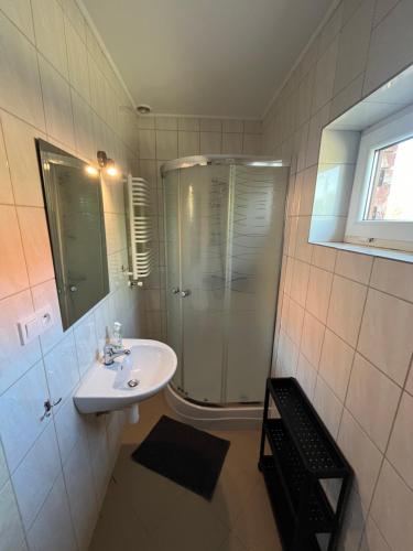 a bathroom with a shower and a sink at Apartament Nostalgia in Gąski