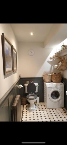a bathroom with a toilet and a washing machine at Woodside in Eartham