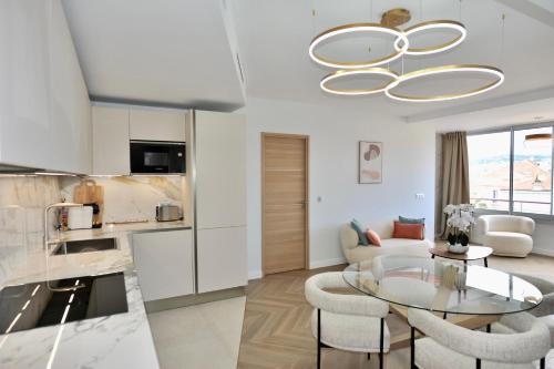 a kitchen and living room with a glass table and chairs at Luxury Romantic Cannes 45 Croisette Two Bedrooms in Cannes