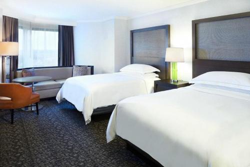 a hotel room with two beds and a couch at Hilton Minneapolis-St Paul Airport in Bloomington