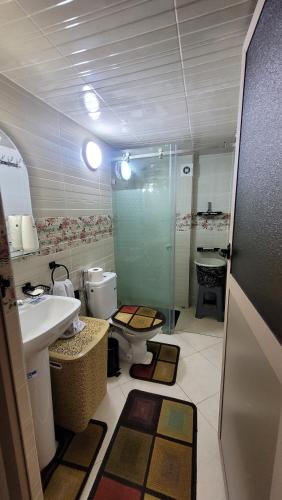 uma casa de banho com um chuveiro, um lavatório e um WC. em Bel appartement dans une résidence calme em Meknès