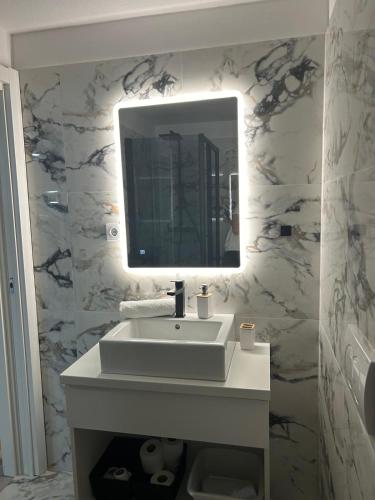 a bathroom with a white sink and a mirror at Villa Bubalo in Omiš
