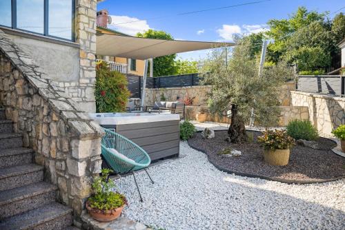 un jardín con un banco y una pared de piedra en Holiday Home Regina, en Kršan