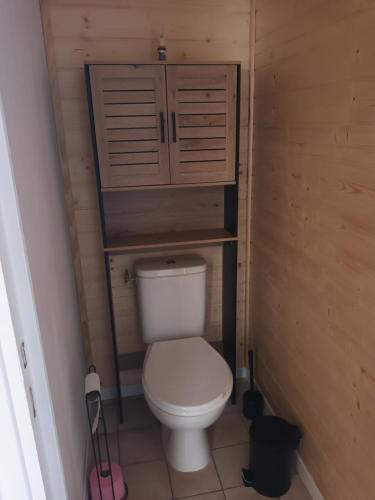 a small bathroom with a toilet with wooden walls at Le Samui in Saint-Hilaire-sur-Yerre
