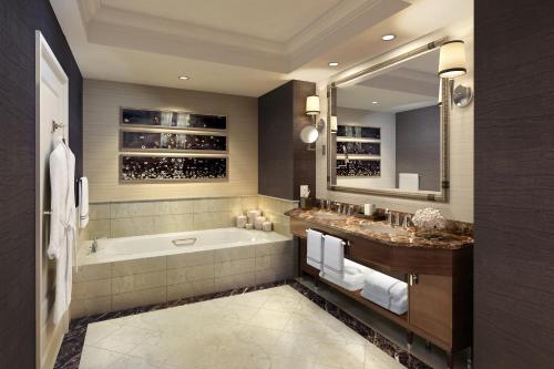 a bathroom with a tub and a sink and a mirror at The Ritz-Carlton, Denver in Denver