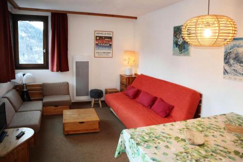 - un salon avec un canapé rouge et un lit dans l'établissement Résidence Le Cairn - APPARTEMENT N° 407 LE CAIRN MAE-6331, aux Orres