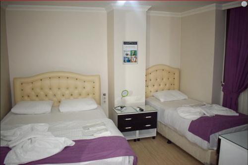 dos camas sentadas una al lado de la otra en una habitación en Kümbet Hotel, en Estambul
