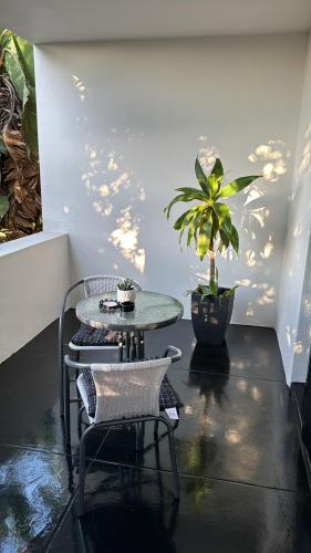 a table and chairs in a room with a potted plant at DUNIYA HOMES in Pretoria