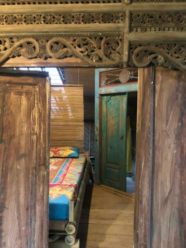 a room with a bed and an open door at Omah Guyub 2 in Jarakan
