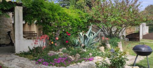 a garden with flowers and a fence and a grill at Lou Boulugi in Aix-en-Provence