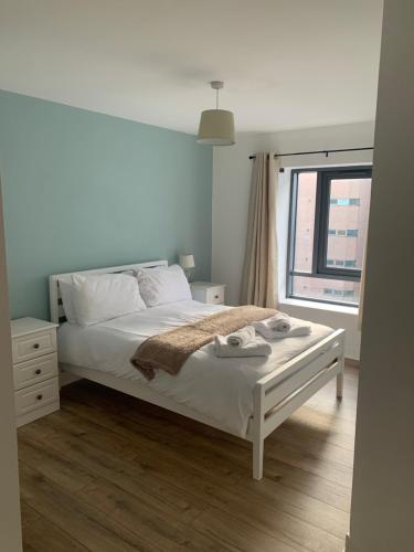 Un dormitorio con una cama blanca y una ventana. en Best Location in Belfast! Free parking, en Belfast