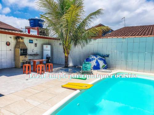 una casa con una piscina y una palmera en Casa Do Mar - Wi-fi - Netflix - Piscina, en Mongaguá