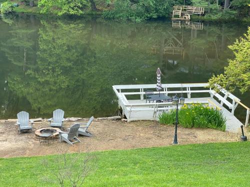 dos sillas y una mesa junto al agua en Lakefront Bubbles & Beach, en Flat Rock