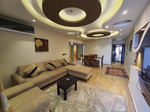 een woonkamer met een bank en een plafond bij Join Inn Apartments in Alexandrië