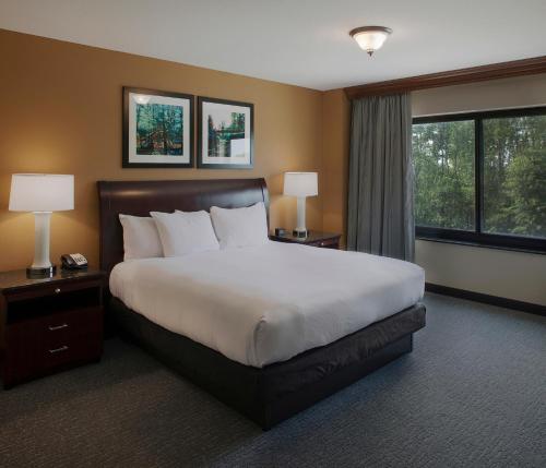 pokój hotelowy z dużym łóżkiem i oknem w obiekcie DoubleTree Suites by Hilton Bentonville w mieście Bentonville