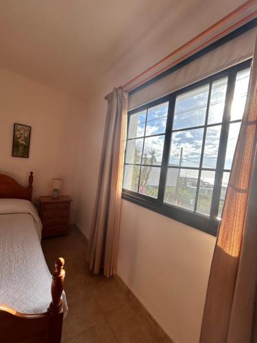 ein Schlafzimmer mit einem Bett und einem großen Fenster in der Unterkunft Casa Atilano Las Puntas La Frontera El Hierro in Las Puntas