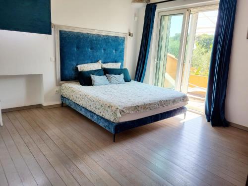 une chambre avec un lit avec une tête de lit bleue dans l'établissement Villa in Biot, à Biot