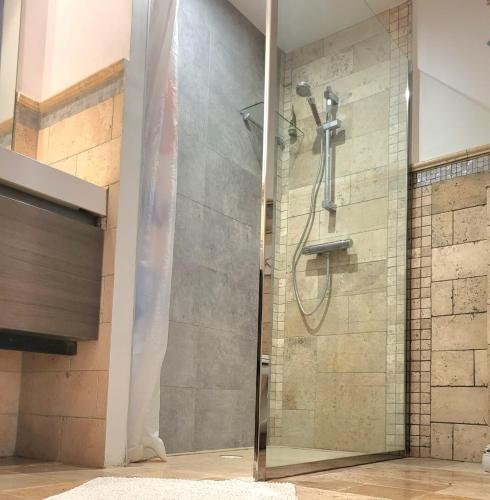 une douche avec une porte vitrée dans une salle de bain dans l'établissement Villa in Biot, à Biot