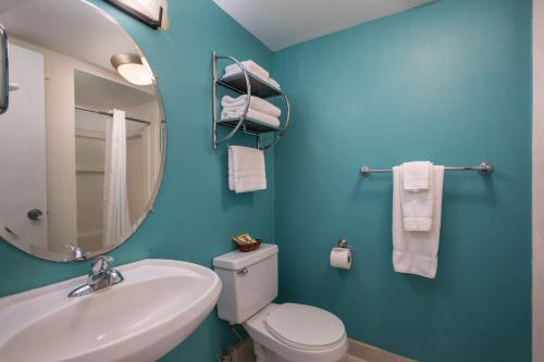uma casa de banho com um lavatório, um WC e um espelho. em Aqua Aloha Surf Waikiki em Honolulu