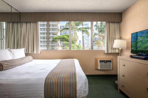 a hotel room with a bed and a large window at Aqua Aloha Surf Waikiki in Honolulu
