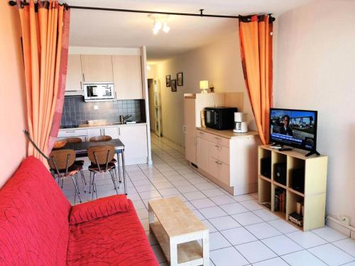 un salon avec un canapé rouge et une cuisine dans l'établissement Résidence Le Neptune - 2 Pièces 4 couchages PORT LEUCATE MAE-8124, à Port-Leucate