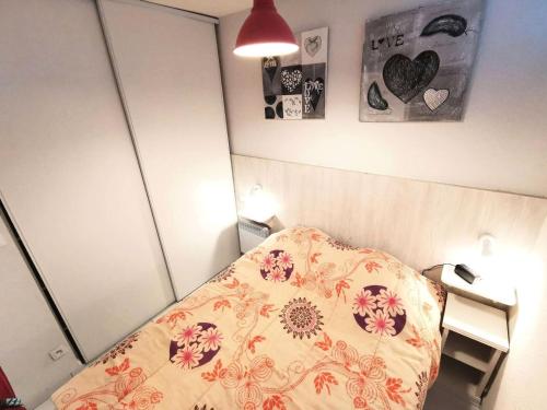 - une chambre avec un lit et une couverture fleurie dans l'établissement Résidence Le Neptune - 2 Pièces 4 couchages PORT LEUCATE MAE-8124, à Port-Leucate