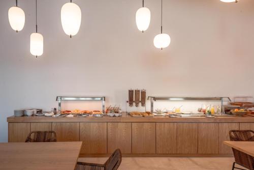 a restaurant with a buffet with tables and lights at Sampatiki Suites & Spa - Luxury Seaview Suites - Opened 2024 in Leonidion