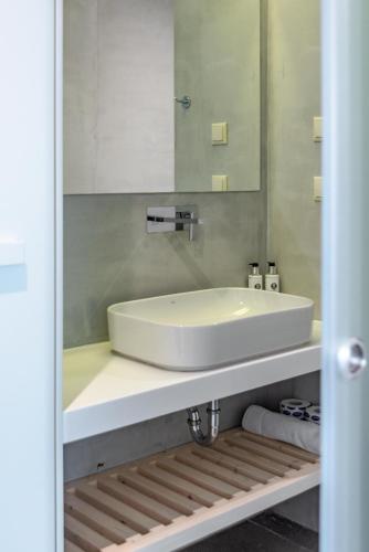 a bathroom with a white sink and a mirror at Sampatiki Suites & Spa - Luxury Seaview Suites - Opened 2024 in Leonidion