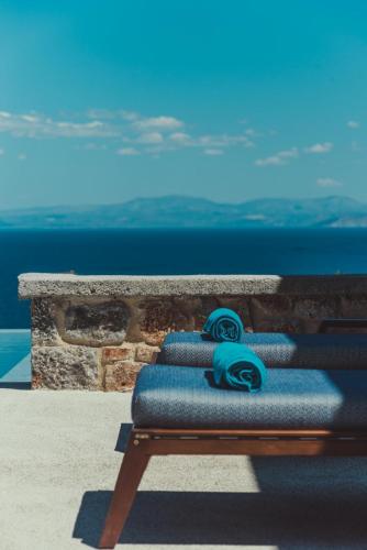 a bench with blue wheels on it next to the ocean at Sampatiki Suites & Spa - Luxury Seaview Suites - Opened 2024 in Leonidion