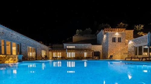 a large blue swimming pool at night at Sampatiki Suites & Spa - Luxury Seaview Suites - Opened 2024 in Leonidion