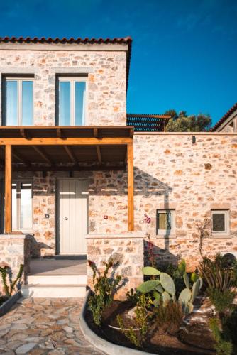 a stone house with a wooden roof at Sampatiki Suites & Spa - Luxury Seaview Suites - Opened 2024 in Leonidion